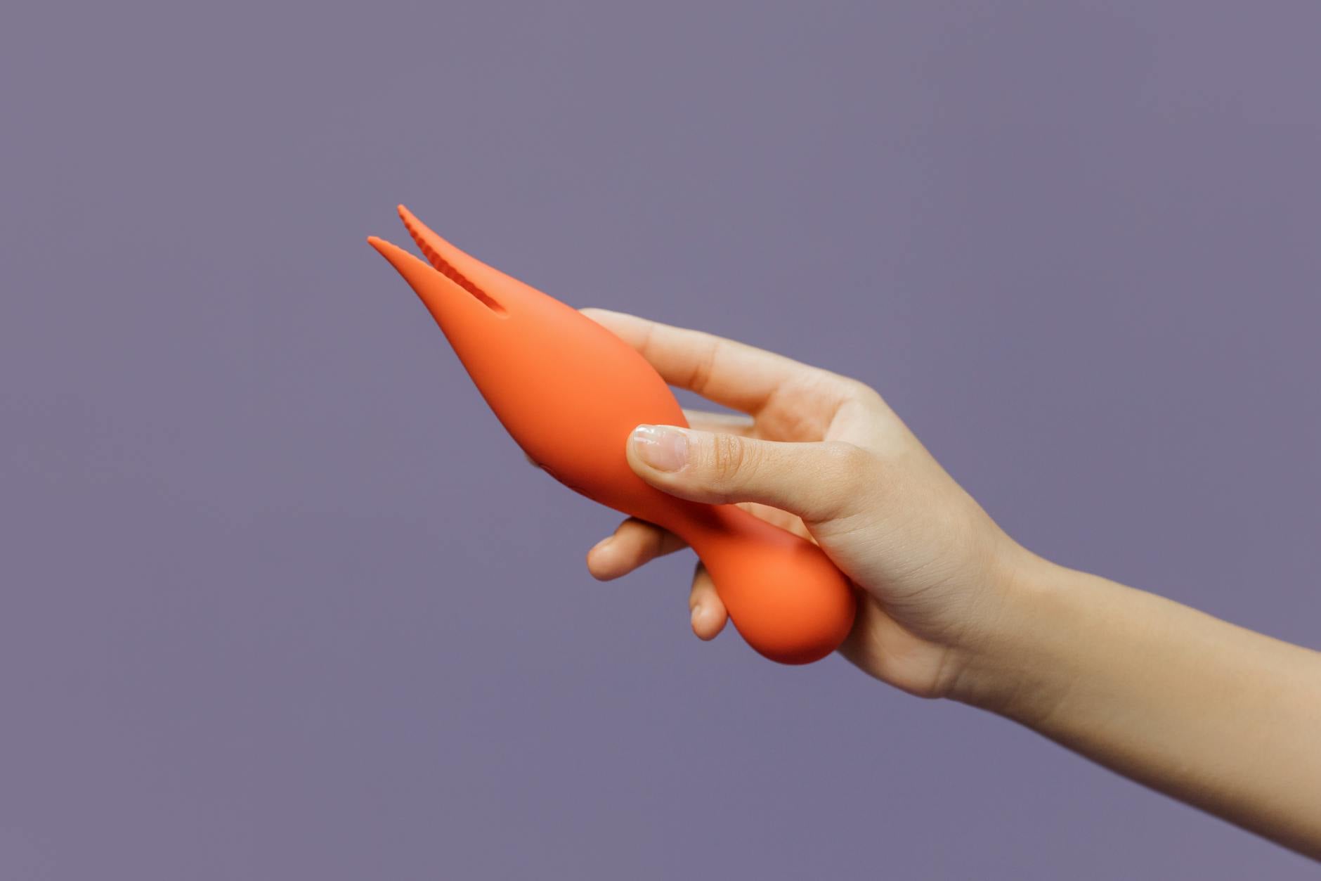 Close-up of a hand holding a vibrator against a minimalistic backdrop, representing sensory awakening and restored pleasure